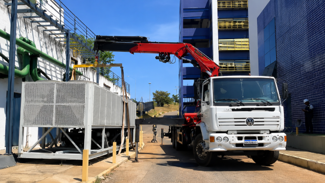 Caminhão munck instalando chiller industrial em planta